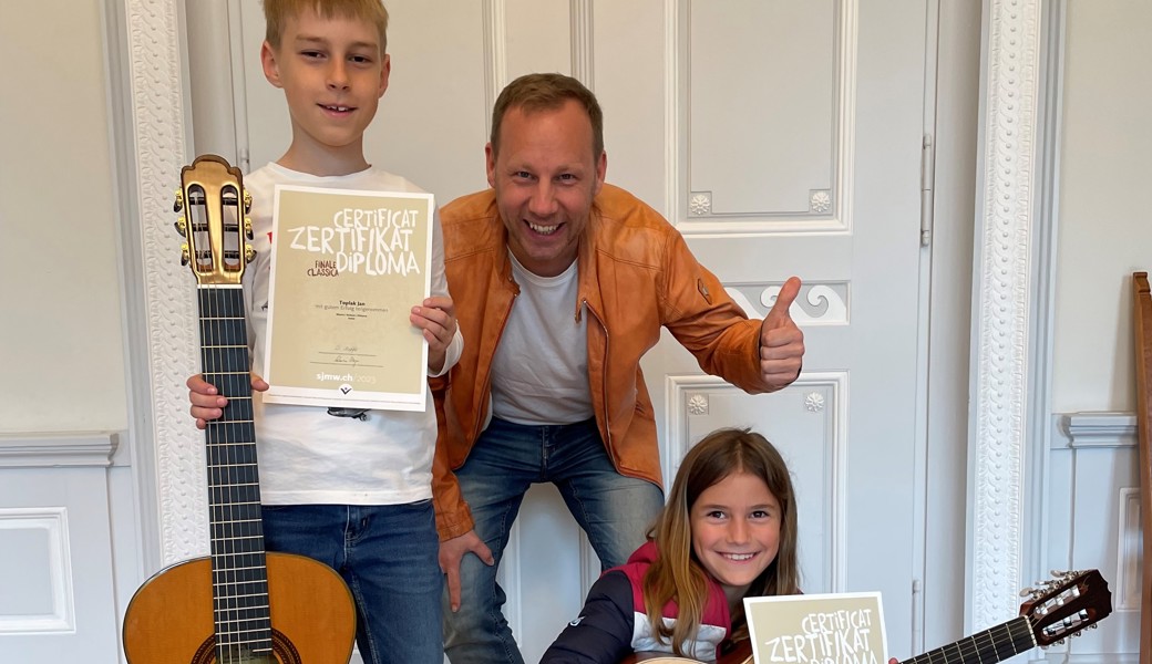 Jan Toplak, Gitarrenlehrer Klaus Wladar und Pia Langenegger freuen sich über die Zertifikate.  