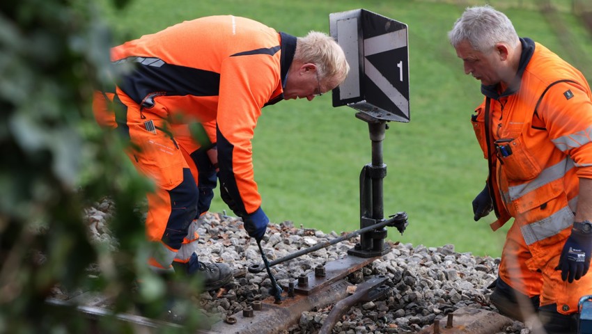 Zwei Bahnarbeiter überprüfen die Weiche an der Unfallstelle.