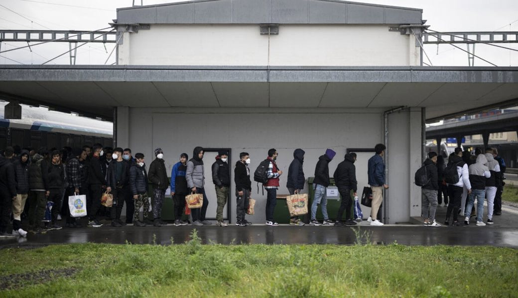  Migranten aus einem Zug aus Österreich werden von Grenzwächtern zur Kontrolle gebracht. Sofern sie nicht zur Fahndung ausgeschrieben sind, dürfen sie danach weiterreisen.