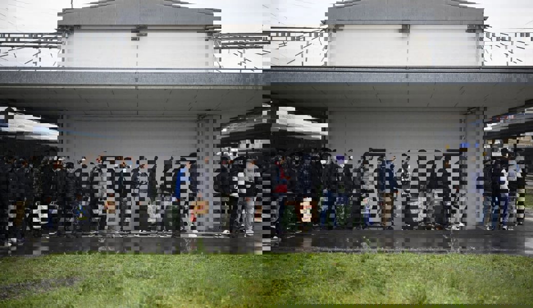  Migranten aus einem Zug aus Österreich werden von Grenzwächtern zur Kontrolle gebracht. Sofern sie nicht zur Fahndung ausgeschrieben sind, dürfen sie danach weiterreisen.