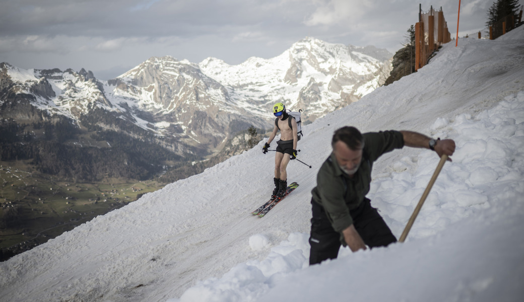 Ein Mitarbeiter der Bergbahnen schaufelt am Chäserrugg Schnee auf eine Piste: Schneesicherheit ist ein wichtiges Thema für die Zukunft.