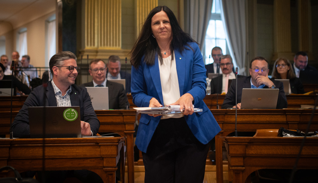 Andrea Abderhalden zügelt mit ihrem Notebook und ihren Arbeitsunterlagen an ihren neuen Platz neben dem Kantonsratspräsidenten.