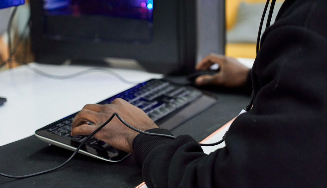 Junge Scammer schauen älteren Scammern in Internetcafés über die Schulter (Symbolbild).