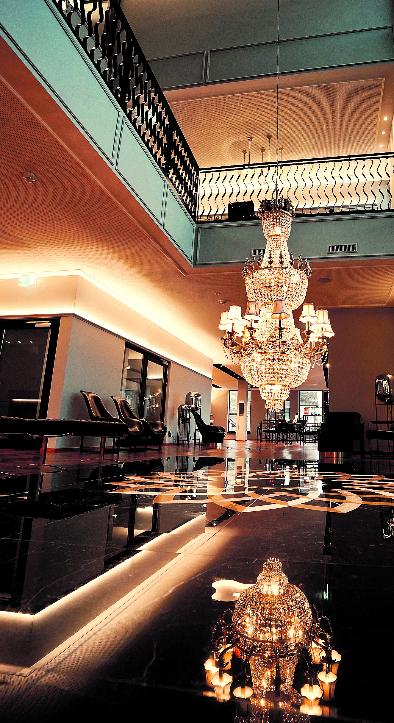 Auffallend in der Empfangshalle: der über drei Stockwerke pendelnde Kristallleuchter und die Marmorintarsien, welche in Form einer Iris gearbeitet sind.