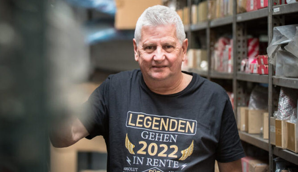  Albert Deplazes in «seinem Reich», dem Ersatzteillager der Riet-Garage AG. Das spezielle T-Shirt haben ihm Kollegen zur bevorstehenden Pensionierung geschenkt. Bilder: Heini Schwendener