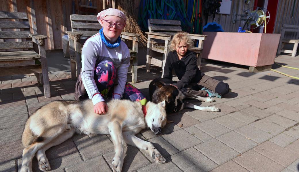 Linda gibt Streicheleinheiten. Der Husky geniesst die Nähe. Rechts: Selina Kobler. 