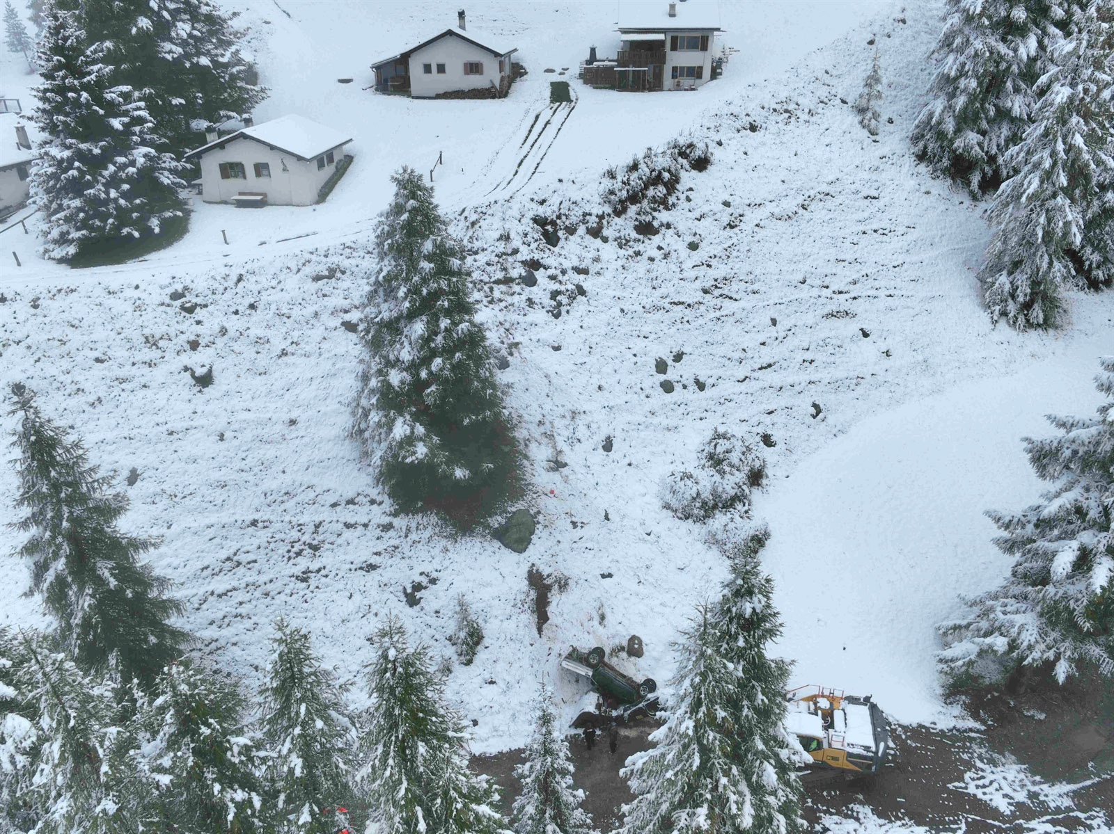 Auto rutscht auf schneebedeckter Wiese und stürzt Abhang hinunter