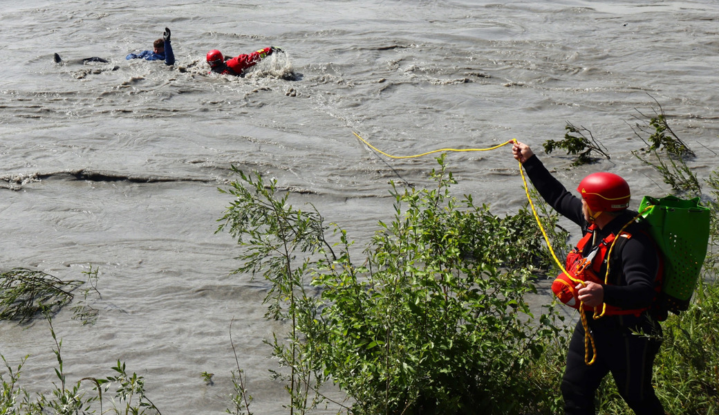 Rettung geglückt: Ein Fliesswasserretter zieht den verunfallten Schlauchbootfahrer aus dem Rhein. Sein Kollege gibt ihm Sicherung. Entscheidend ist, dass die Retterinnen und Retter so schnell wie möglich am Einsatzort sind.