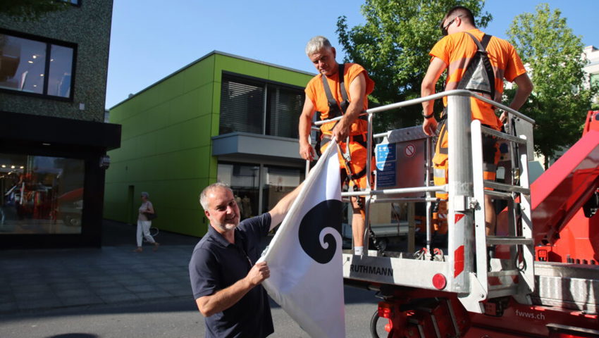  Rolf Pfeiffer übergibt die nächste Fahne zum Aufhängen. 