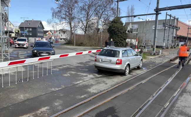 Auto auf Bahnübergang blockiert und von Zug gestreift