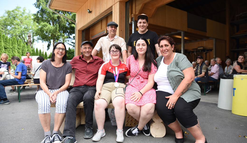 Olympiasiegerin Laura Signer und Familienangehörige versammelten sich zum Gruppenbild bei der Holzbank, dem Geschenk der Gemeinde Sennwald.