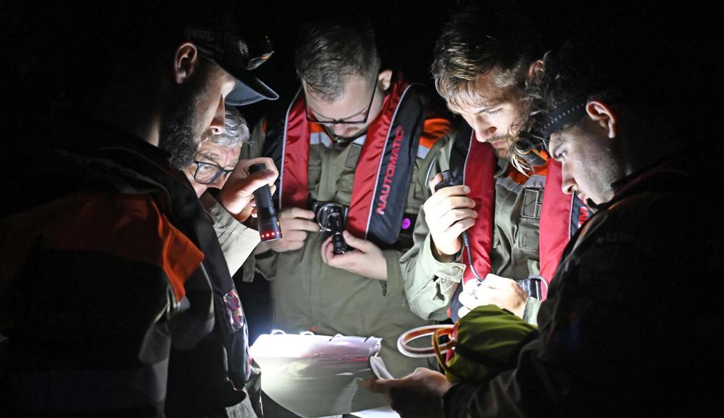 Trotz völliger Dunkelheit müssen die Einsatzkräfte den Überblick bewahren: Eine Patrouille berät sich an einer gefundenen Schwachstelle. Sie müssen Position und Art der Beobachtung genaustens dokumentieren.