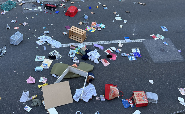 Verwirrte Frau wirft Gegenstände auf Strasse