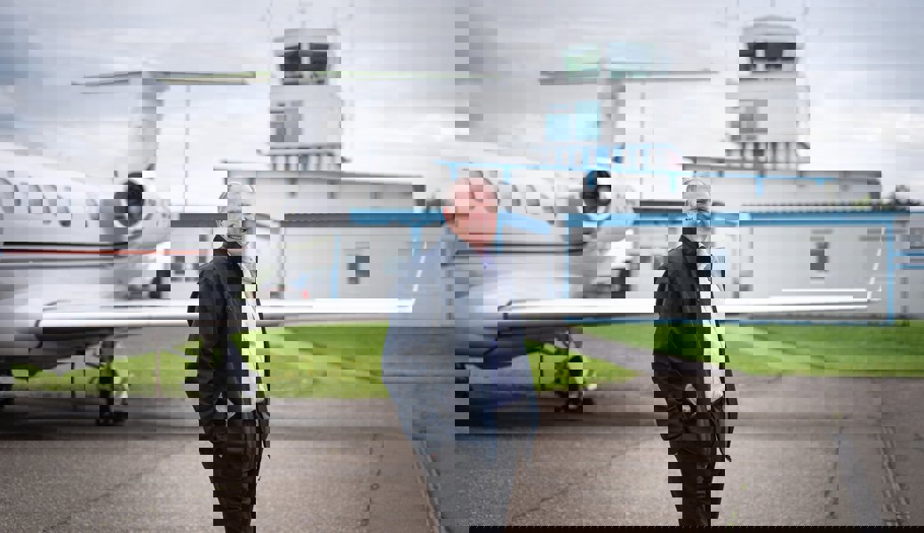 Alex Bristol mit dem Tower des Flugplatzes Altenrhein im Hintergrund. Er sieht trotz drohender Sparmassnahmen eine Zukunft für den Standort. 