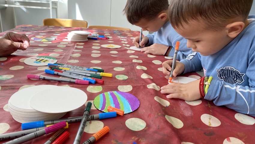 Die Kinder bemalten Kartondeckel, die sie anschliessend für Spiele nach Hause nehmen konnten.