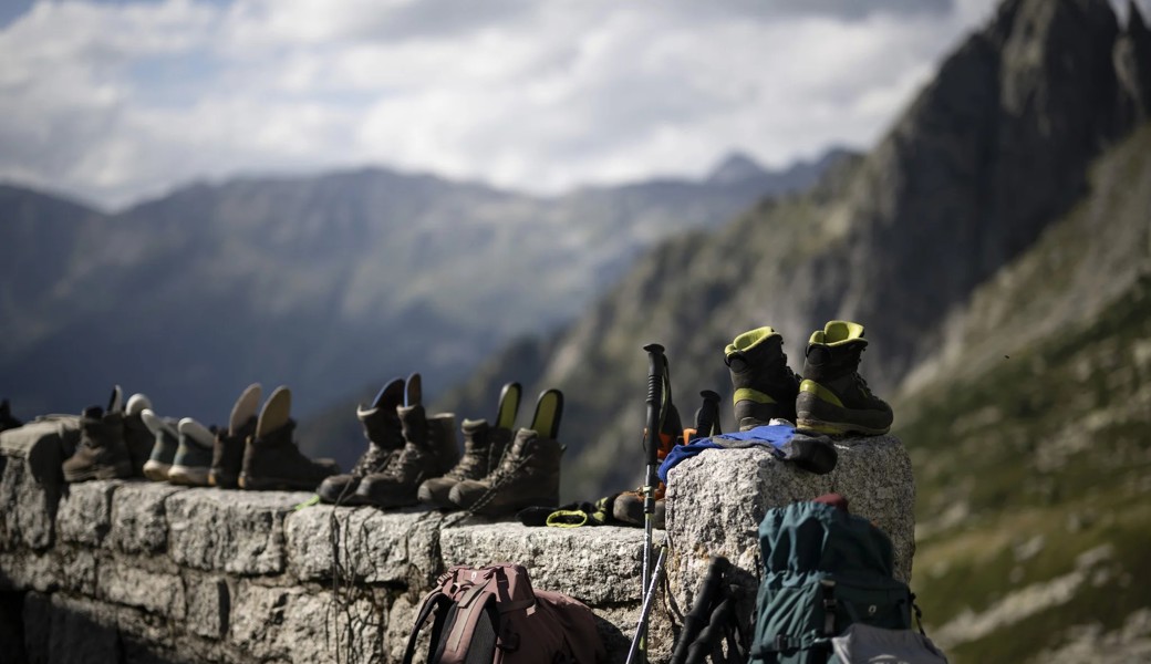 Wenn die Wandersaison in den Bergen beginnt, füllen sich auch die SAC-Hütten wieder: Wanderschuhe stehen vor der Hütte Sciora im Bergell.