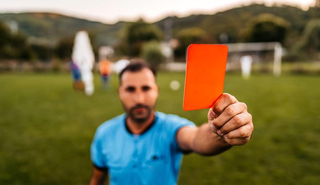 Massnahmen der Schiedsrichterinnen und Schiedsrichter, wie eine rote Karte führen oft zu Ausschreitungen im Amateurfussball.
