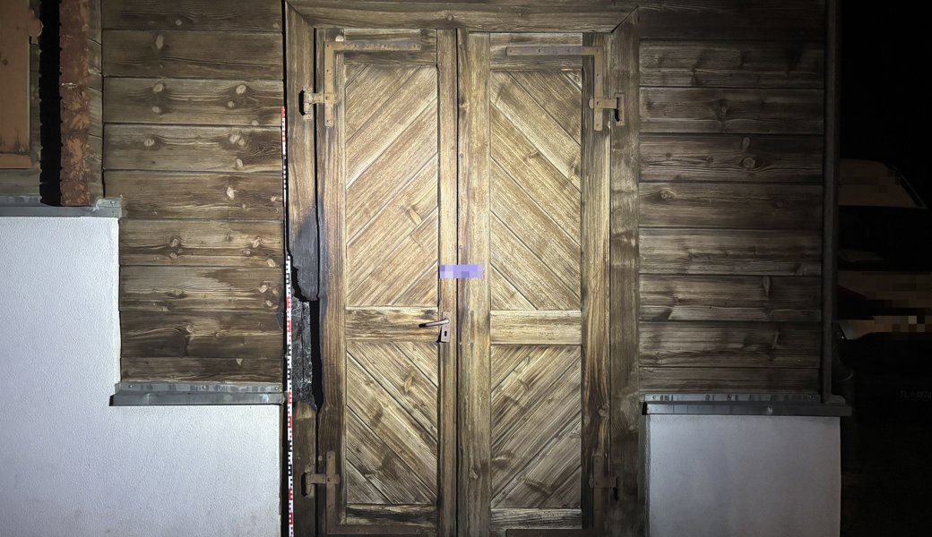 Feuer an Holztüre eines leerstehenden Holzhauses