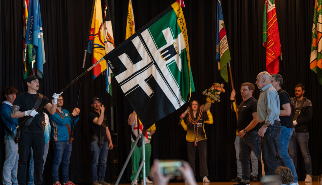 Stolz präsentiert der Fähnrich des TV Buchs dem Publikum die neue Vereinsfahne.