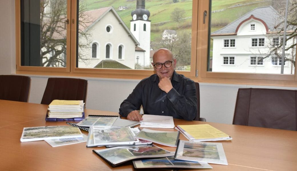 Rolf Züllig sitzt vor den Unterlagen der Hotel-Acker-Projekten. 