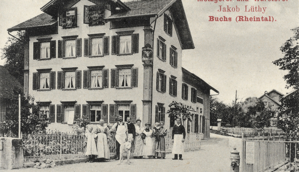 Die Metzgerei und Wursterei Lüthy 1907 mit Belegschaft (von links): Babettli Lüthy, Katharina Lüthy-Schindler, Jakob Lüthy, Michael Schindler, Elsa Schindler-Bretscher, Göldis Gretli, Elsbeth Schindler-Rohrer mit Heinrich, Jakob Capeder. In den Fenstern des Kreuzfirstes sind «Lanteeger» zum Trocknen aufgehängt.