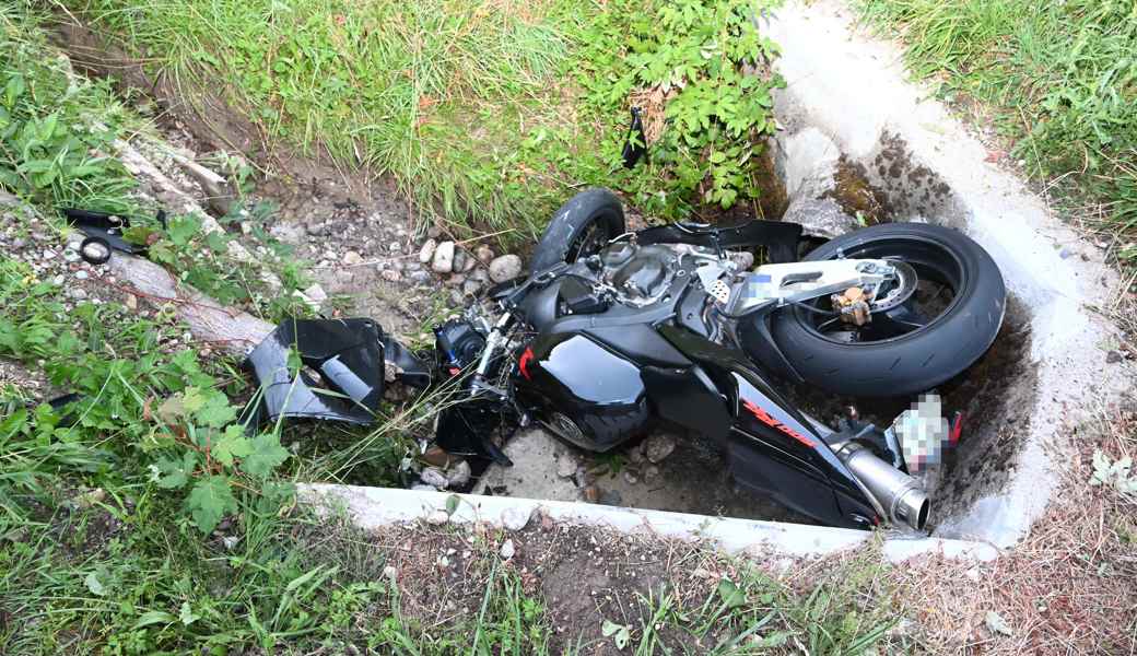 Beim Sturz in den Bachdurchlass wurde der Fahrer über den Töff hinweg auf die Strasse geschleudert.