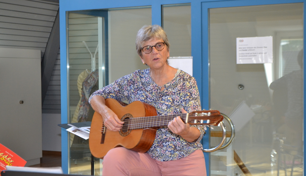 Kursleiterin Christel Kaufmann zeigt den Teilnehmerinnen, wie Lieder auf der Gitarre begleitet werden können.