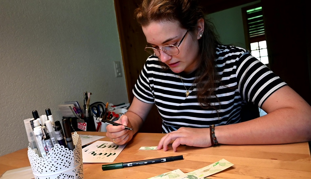 Fokussiert: Siri Tschirky Bleichenbacher beim Gestalten von Glückwunschkarten, Gutscheinen und Gästetischkärtchen.