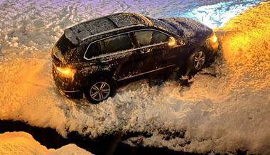 Mit Autos in Bachbett und in Schild gerutscht