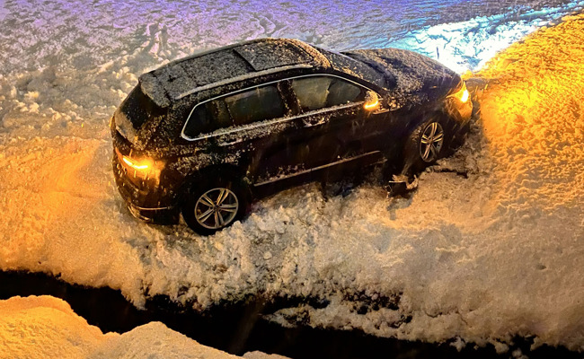 Mit Autos in Bachbett und in Schild gerutscht