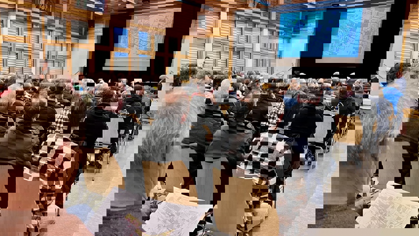  Während Rolf Züllig die Situation des Projekts auf der Leinwand erklärt, studieren einige den Plan in der Broschüre. 