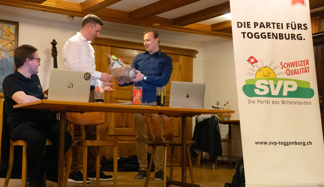 Der neue Präsident Lukas Huber (ganz rechts) übergibt dem abtretenden Präsidenten Thomas Bösch (Mitte) ein Präsent. 