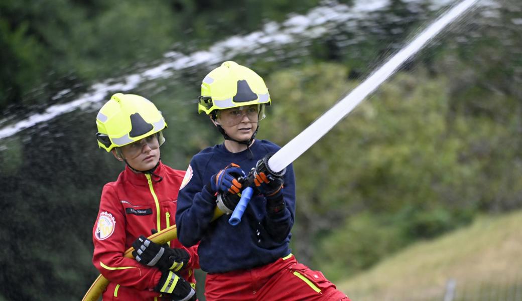 Zwei Mitglieder der Jugendfeuerwehr halten auf Höhe des Hofs Pfüfis ein Strahlrohr unter Kontrolle. Damit steht fest: Der Wassertransport ist geglückt.