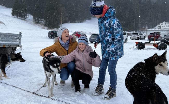Kinder und Huskies trotzen dem Schneegestöber
