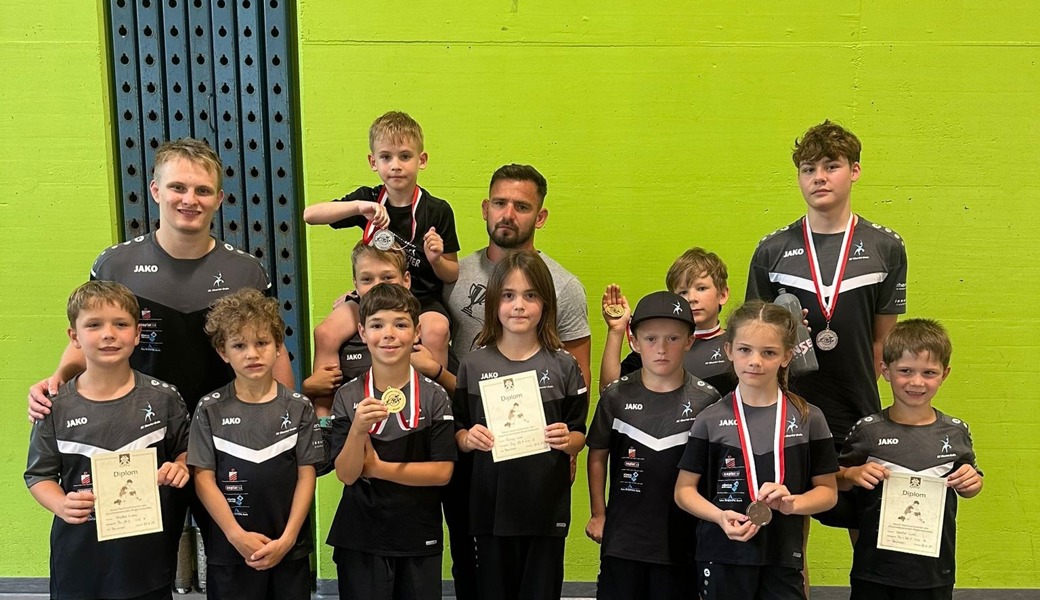Die Coaches Janis Steiger (hinten-links) und Gabor Molnar (hinten in der Mitte) freuten sich mit den Ringerinnen und Ringern über die vielen Medaillen und Diplome.