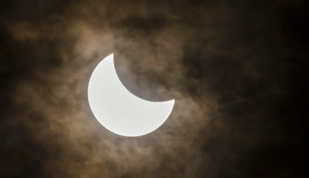 Bei einer partiellen Sonnenfinsternis schiebt sich der Mond vor die Sonne und verdeckt sie teilweise.