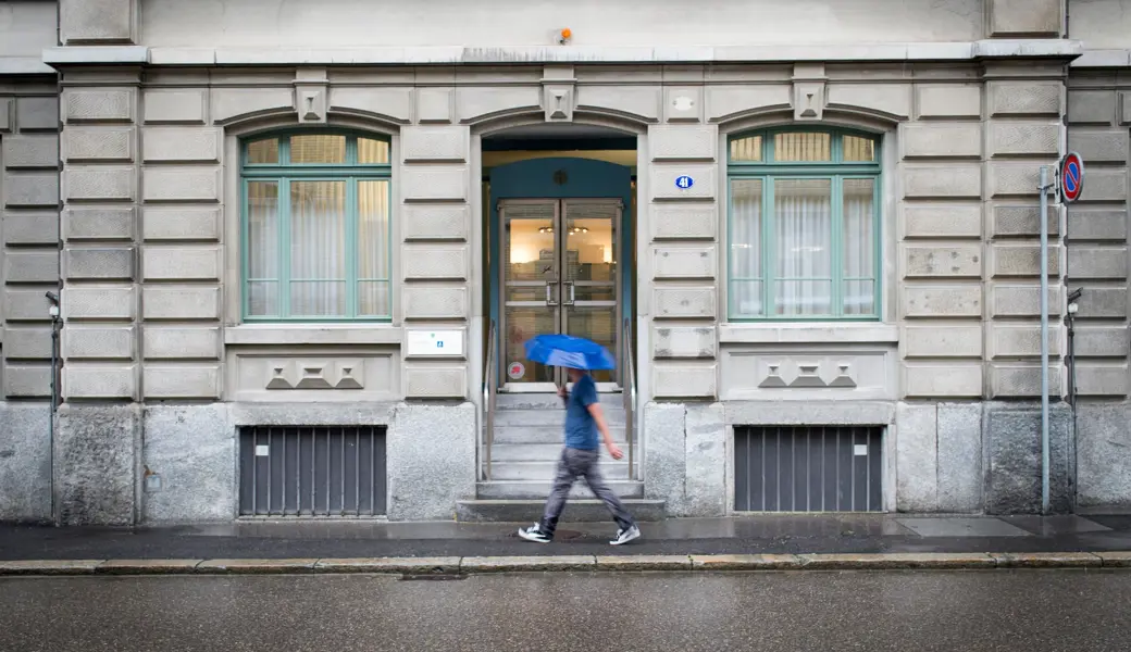 Einige Gemeinden werden sich mit höheren Steuerfüssen für finanziell unsichere Zeiten wappnen, so wie sich dieser Mann vor dem Steueramt des Kantons St.Gallen vor dem Regen schützt.