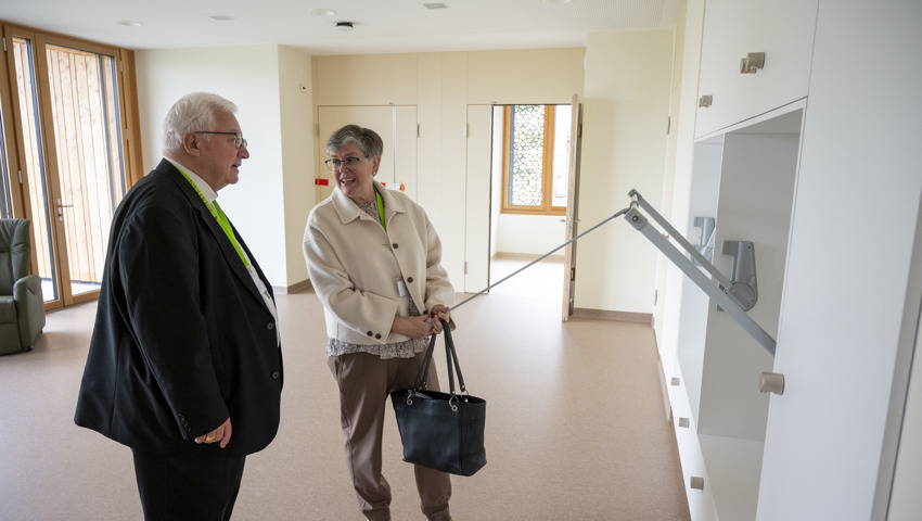 Barbara Dürr erklärt Bischof Markus Büchel die behindertengerechte  Einrichtung des Neubaus. 