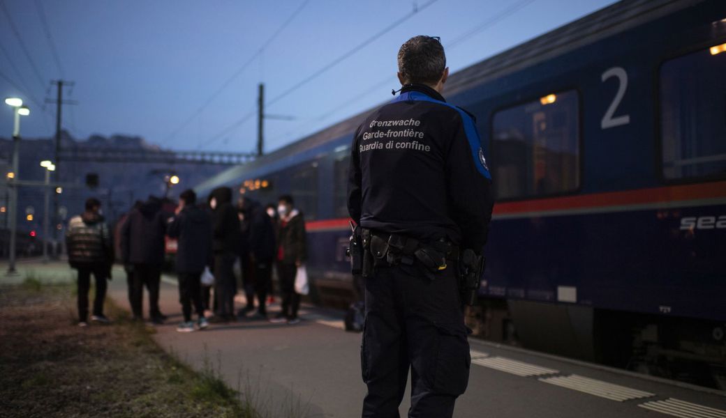 Grenzwaechter bringen Fluechtlinge aus einem Zug aus Wien zur Kontrolle, am Freitag, 19. November 2021, am Bahnhof in Buchs. Seit dem Sommer gelangen vermehrt afghanische Fluechtlinge an den Grenzbahnhof. 