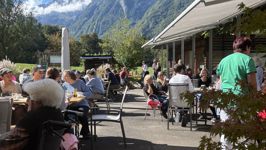 Die Gäste geniessen Kaffee und Kuchen im Garten der neuen Cafeteria.