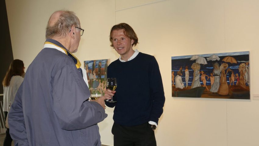  Nico Ramon Kastner im Gespräch mit einem Vernissage-Besucher. Im Hintergrund das 2022 entstandene Bild «Der Tod in Venedig». 