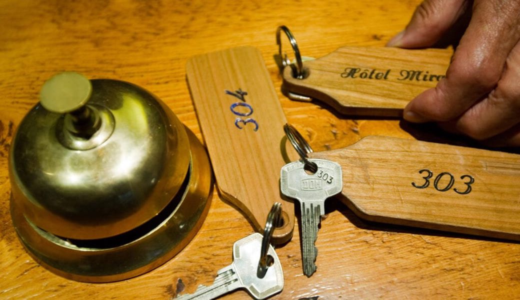  Glocke und Zimmerschlüssel an einer Hotelrezeption. Symbolbild: Jean-Christophe Bott/Keystone