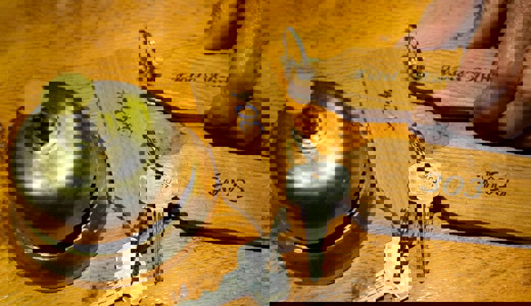  Glocke und Zimmerschlüssel an einer Hotelrezeption. Symbolbild: Jean-Christophe Bott/Keystone