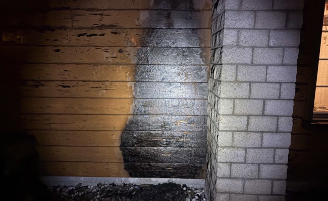 Hausfassade wegen nicht abgekühlter Asche in Brand