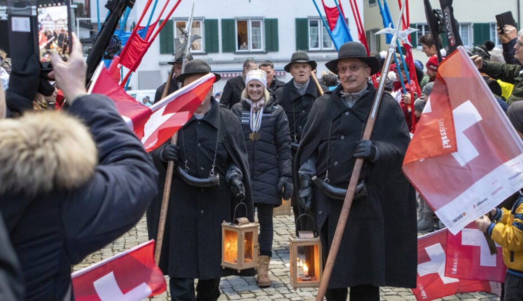  Würdiger Empfang: Mit den Melser Nachtwächtern als «Begleitschutz» sowie mit der Gold- und Bronzemedaille der Weltmeisterschaft in Bakuriani um den Hals, läuft Julie Zogg auf dem Dorfplatz ein. 