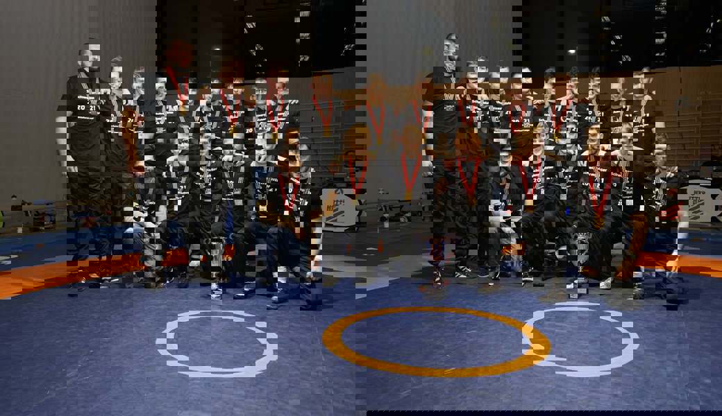 Die strahlenden Gewinner zeigen ihre Medaillen und den Pokal. 